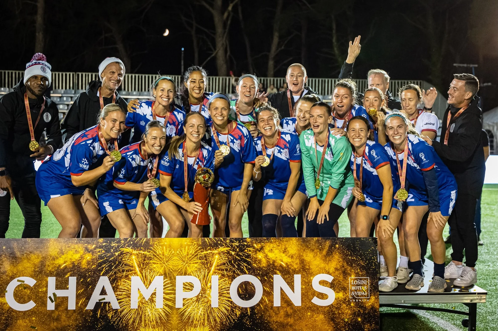 Mini Football USA women players and staff celebrate with the WMF World Cup trophy